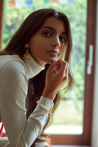 Close-up of pearls and gold-plated charms on the adjustable bracelet